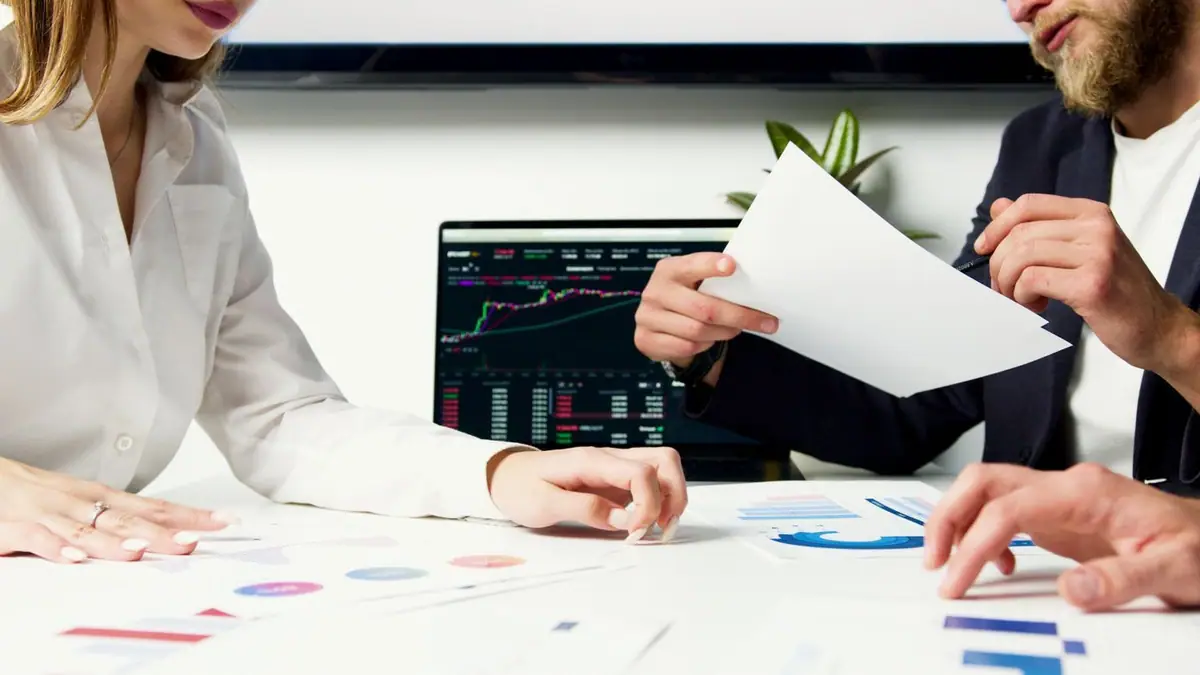 Equipo analizando gráficas financieras en una pantalla
